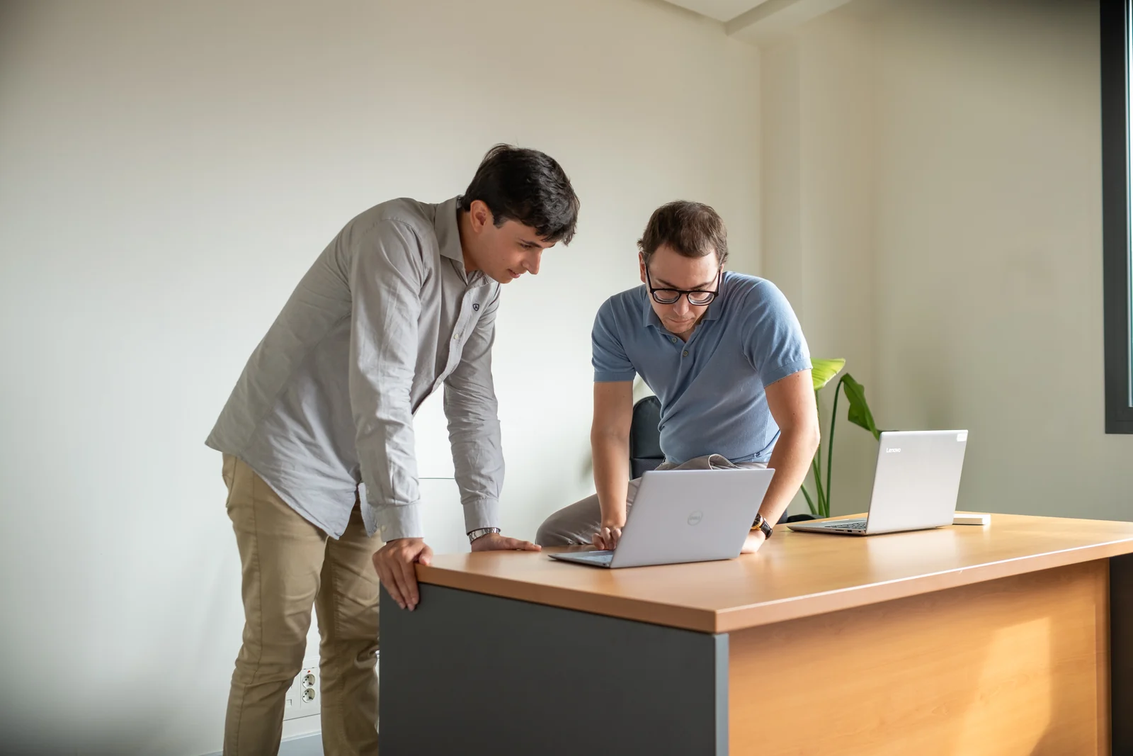 Two Lessthan3 colleagues reviewing work together at a standing desk